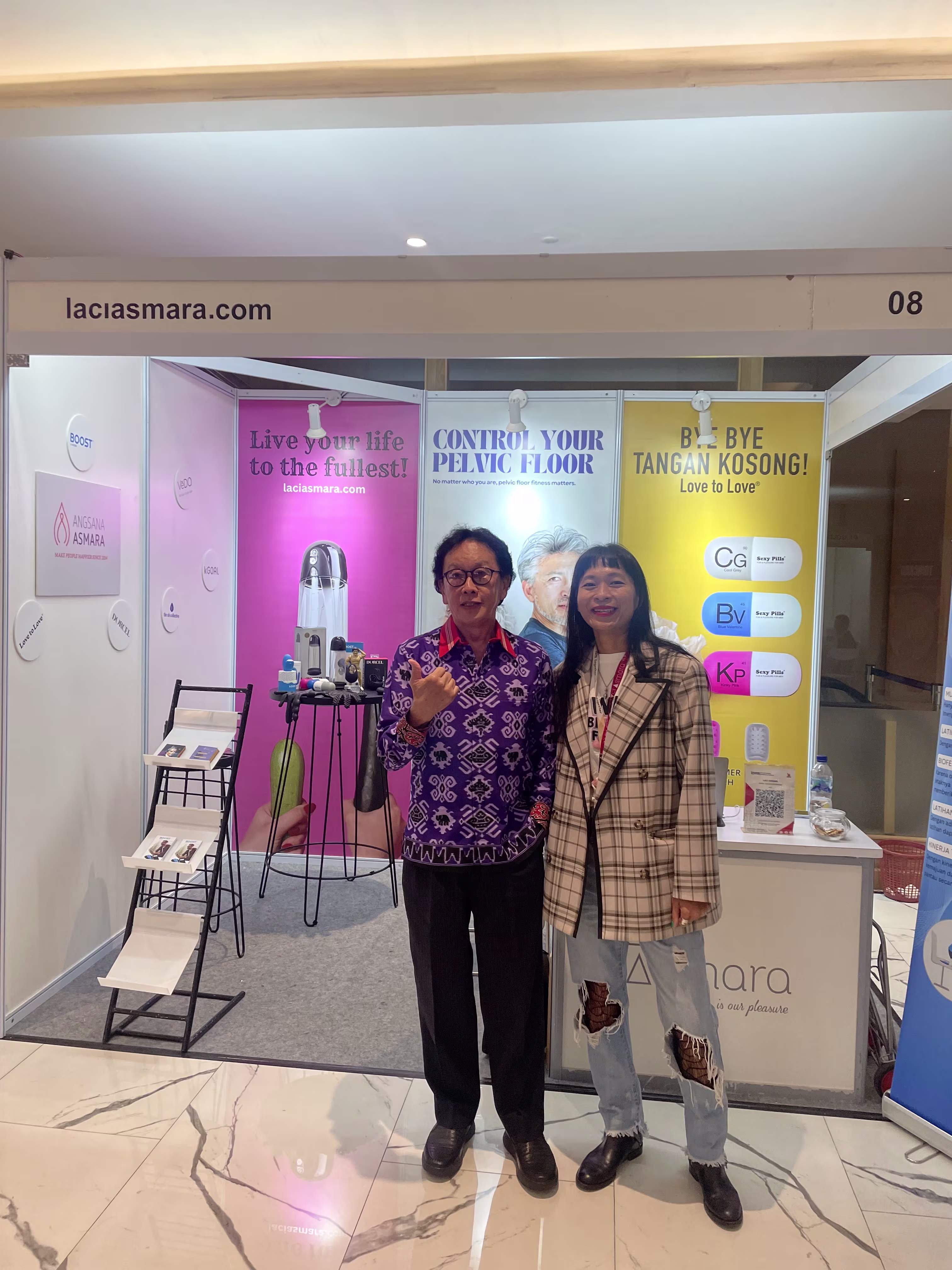 Prof. Dr. dr. Wimpie Pangkahila, Sp.And(K), FAACS posing with Rendra Susanti at the Laciasmara booth during PIT PERSANDI XIV