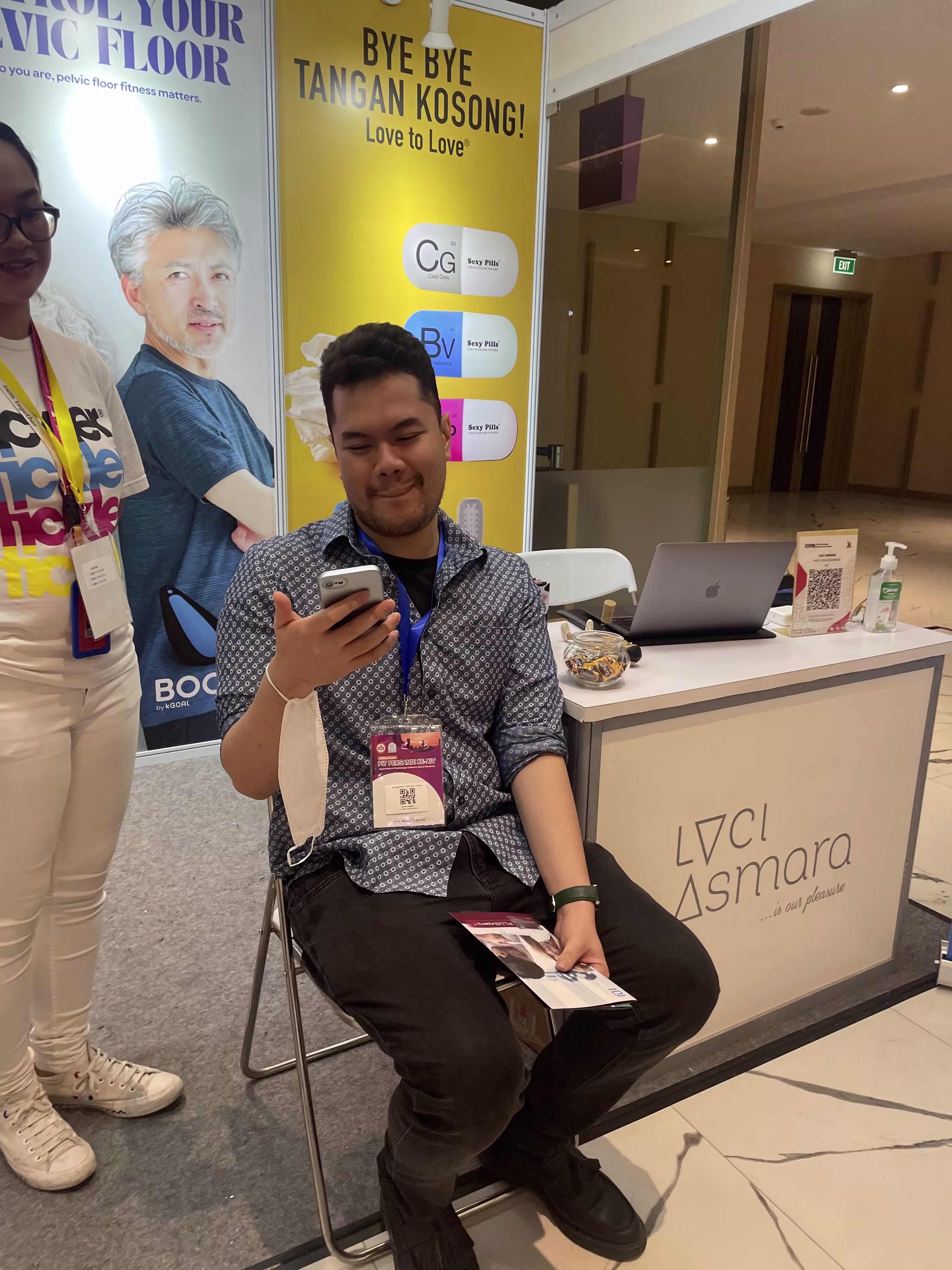 dr. Galih trying out the Boost Kegel exerciser with the assistance of a Laciasmara staff member during PIT PERSANDI XIV 2023