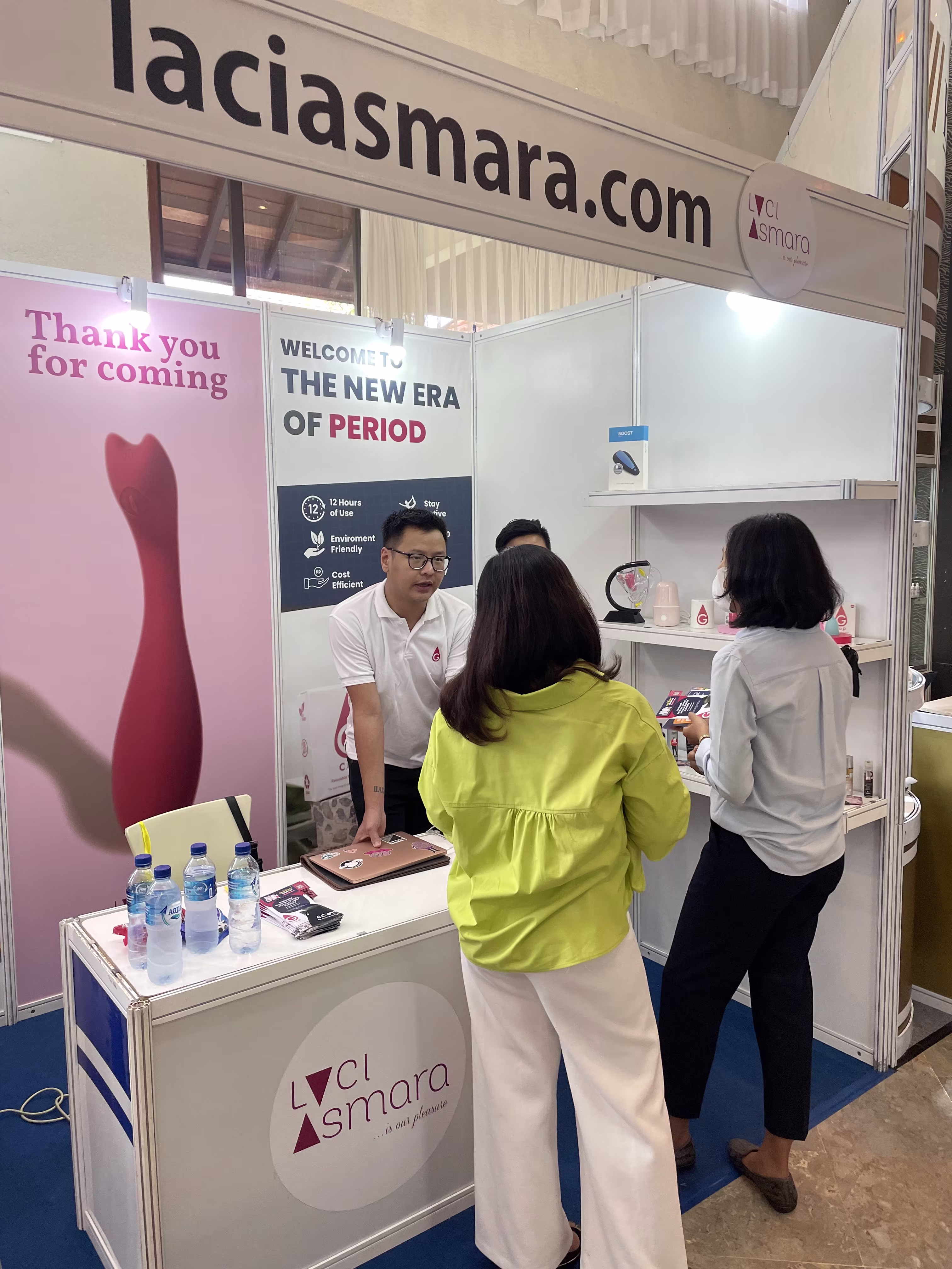 A visitor listening to Hans from GCUP explaining a product at the Laciasmara booth during NASWAAM 2023