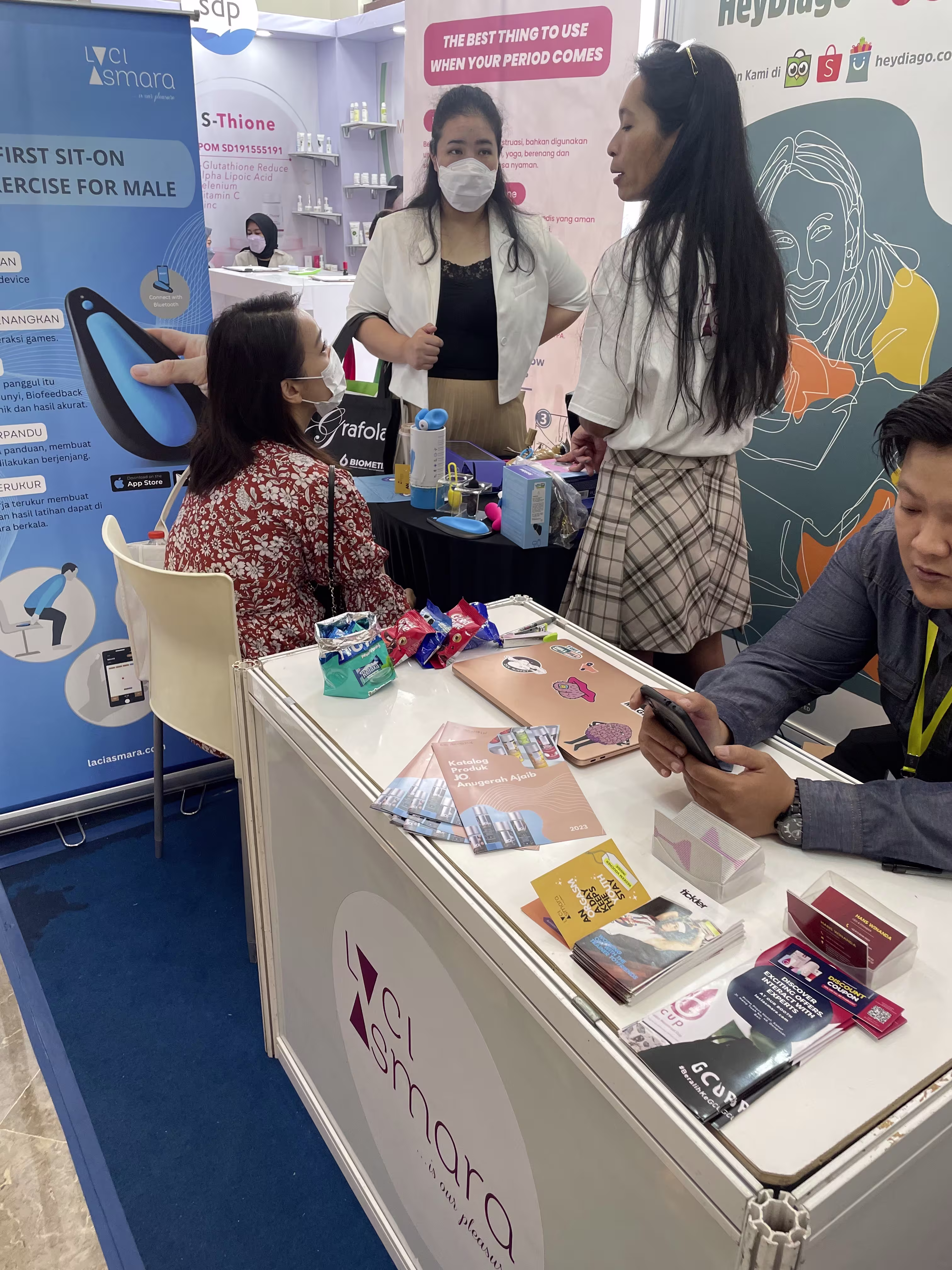 A visitor trying out the kGoal Boost pelvic floor trainer while receiving a consultation from Laciasmara founder Rendra Susanti at NASWAAM 2023