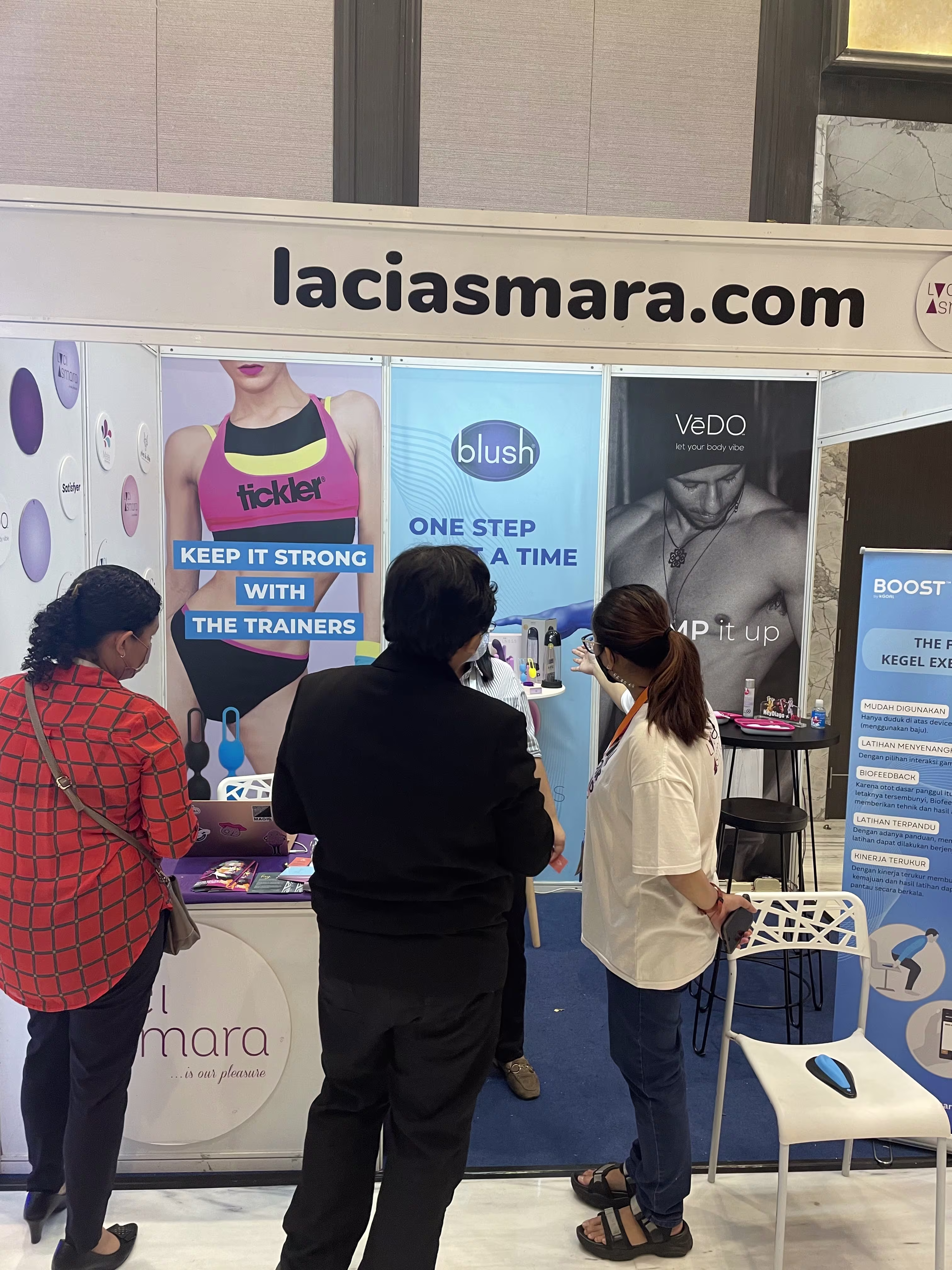 An attendee browsing intimate wellness products at the Laciasmara booth during Kongres Nasional IV Asosiasi Seksologi Indonesia