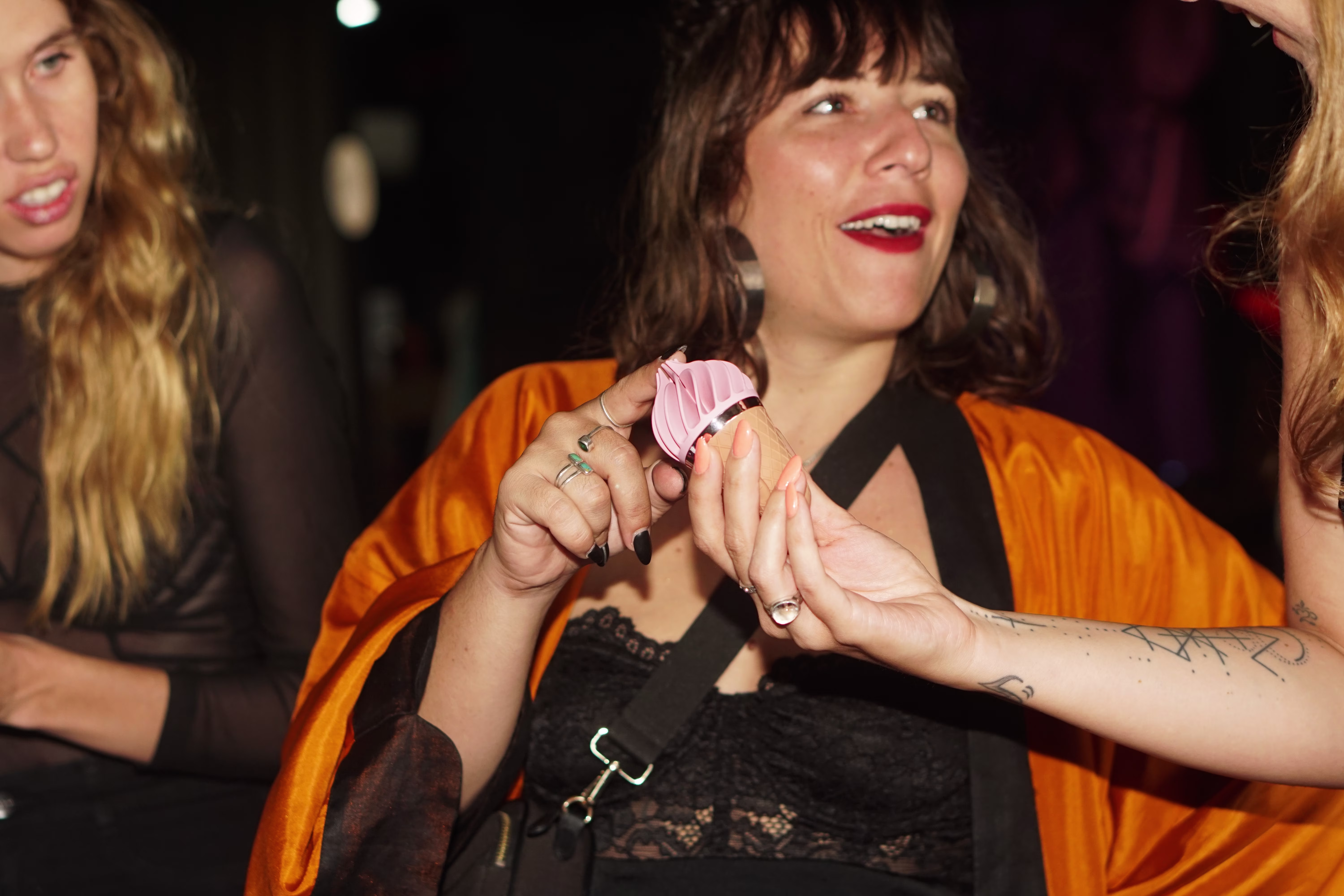 An attendee interacting with and learning about a novelty ice cream-shaped vibrator during the Asmaradoor sexual education event at Joshua District