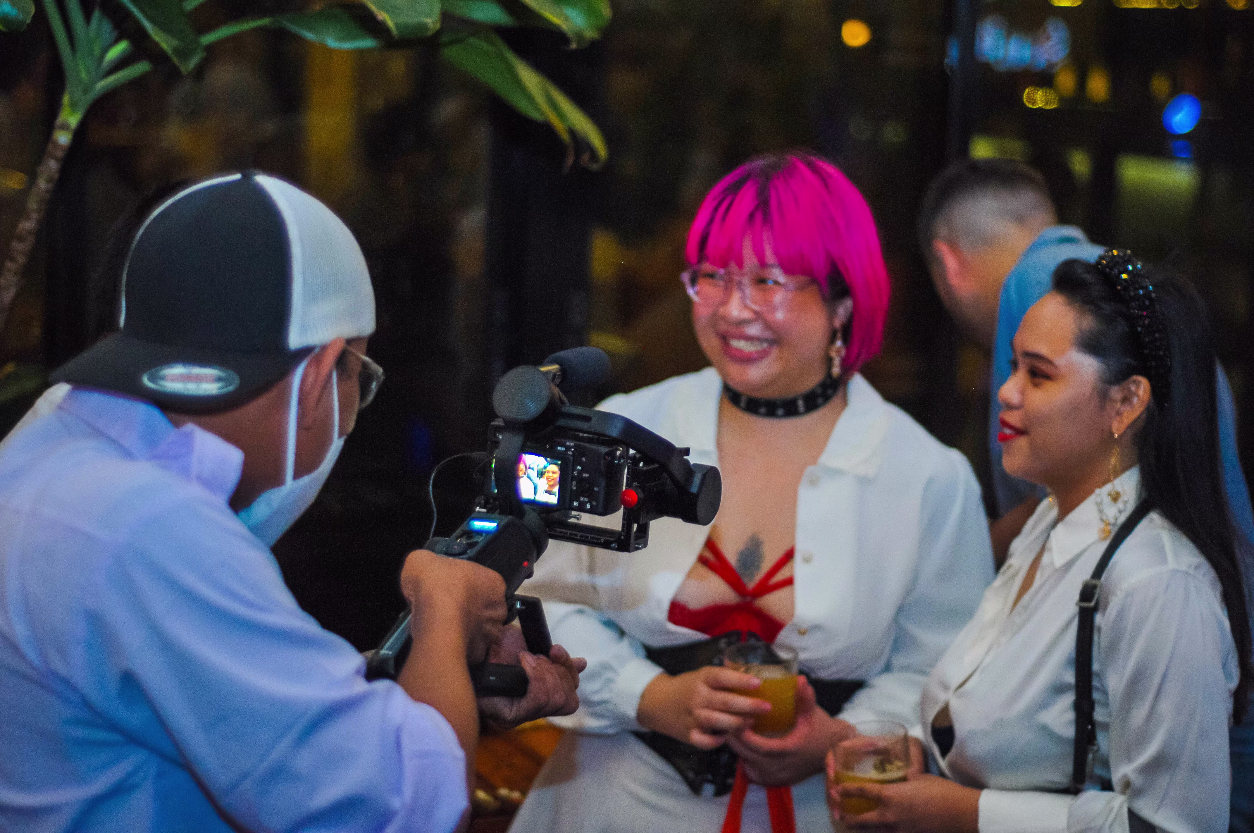 Two women being interviewed and creating content with a photographer at the Teman Asmara Bersua event celebrating the 7th anniversary of Laciasmara at ¡Porqué No!, Jakarta