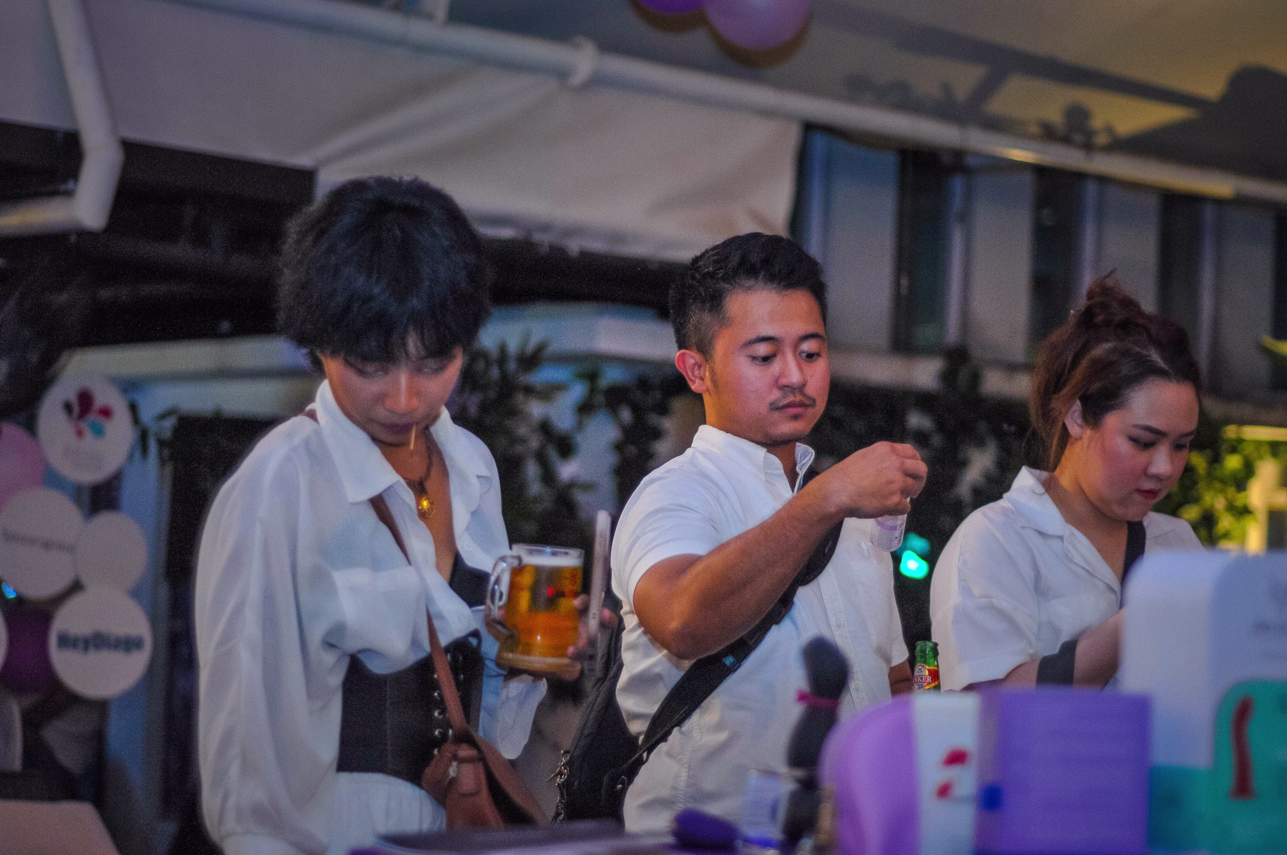An interested guest examining the adult novelty and wellness products on display at the ¡Porqué No! rooftop venue