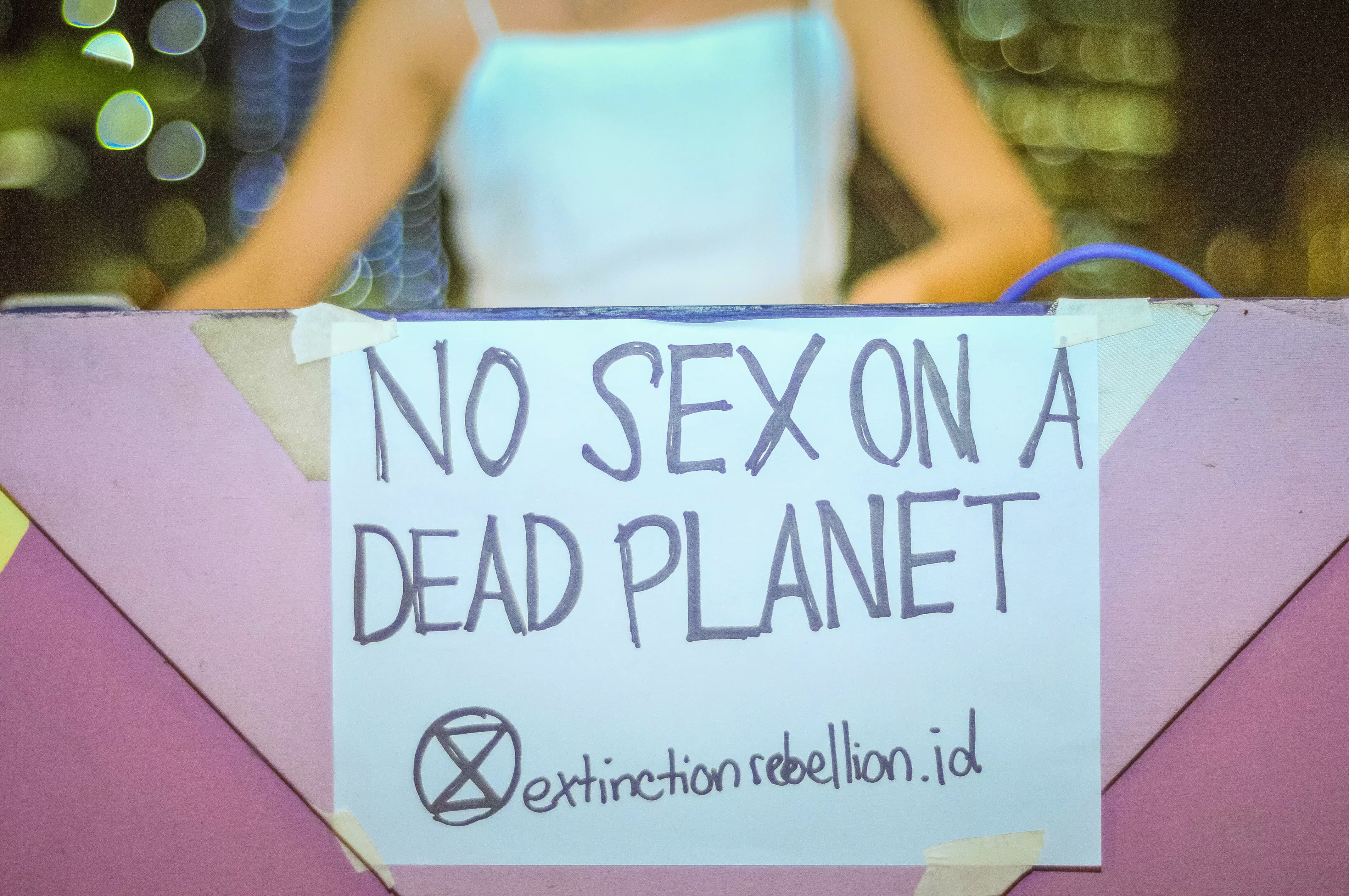 Front view of the DJ booth setup featuring the iconic 'NO SEX ON A DEAD PLANET' statement sign at the Laciasmara anniversary party