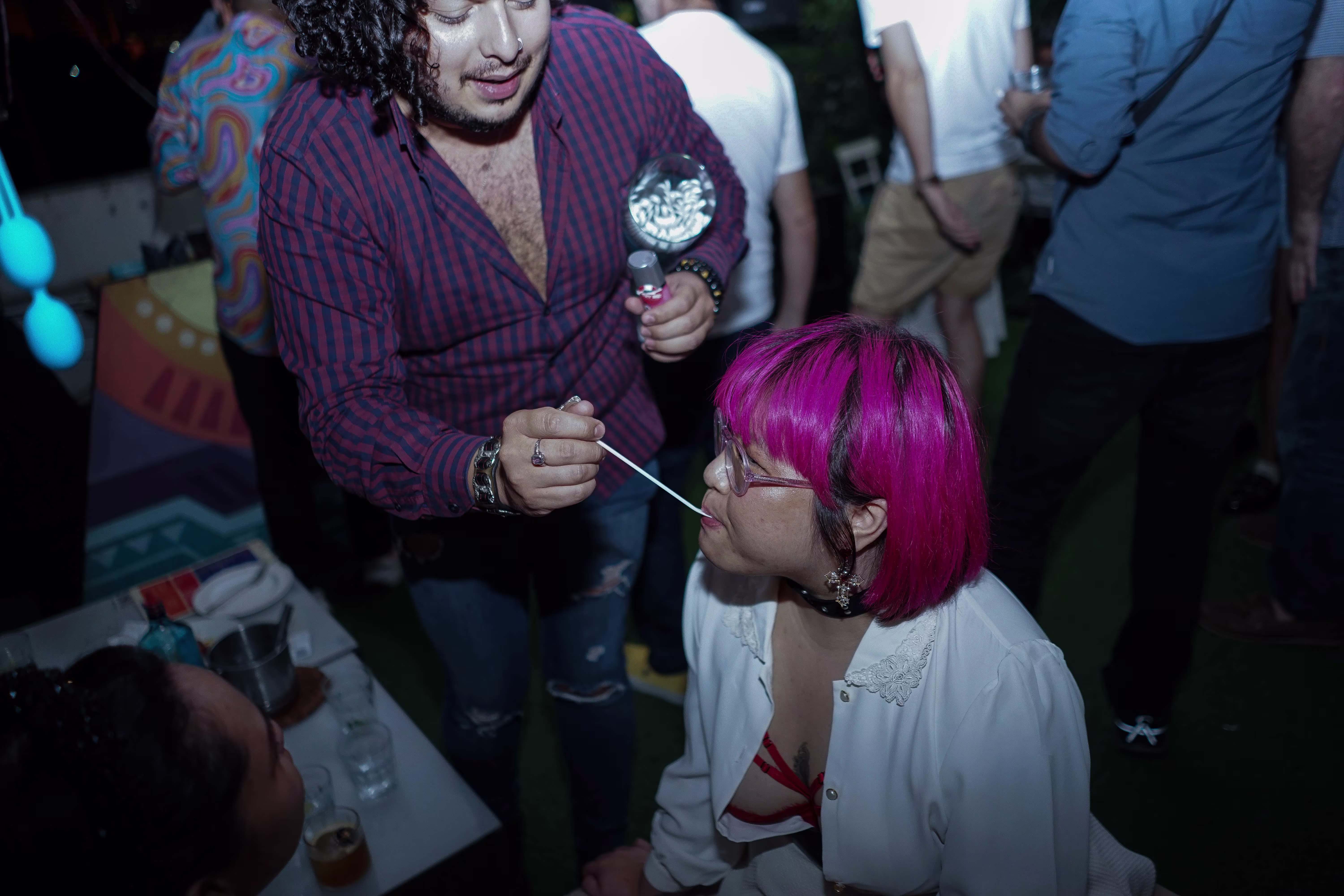 A man and a woman laughing and enjoying a lively conversation during the Teman Asmara Bersua community event at ¡Porqué No!