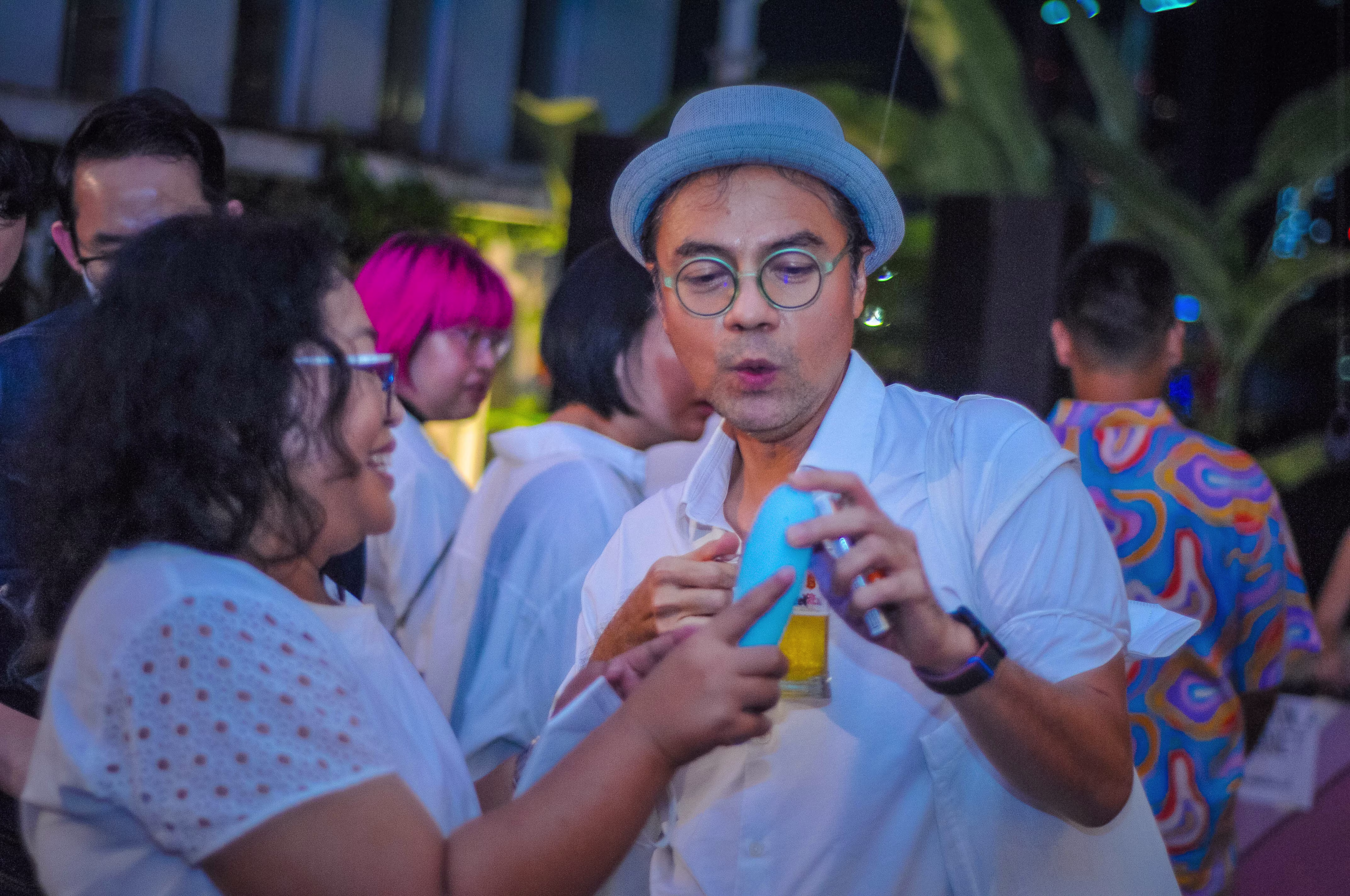 A man and a woman interactively testing the settings of a Laciasmara vibrator together at the 7th anniversary community party