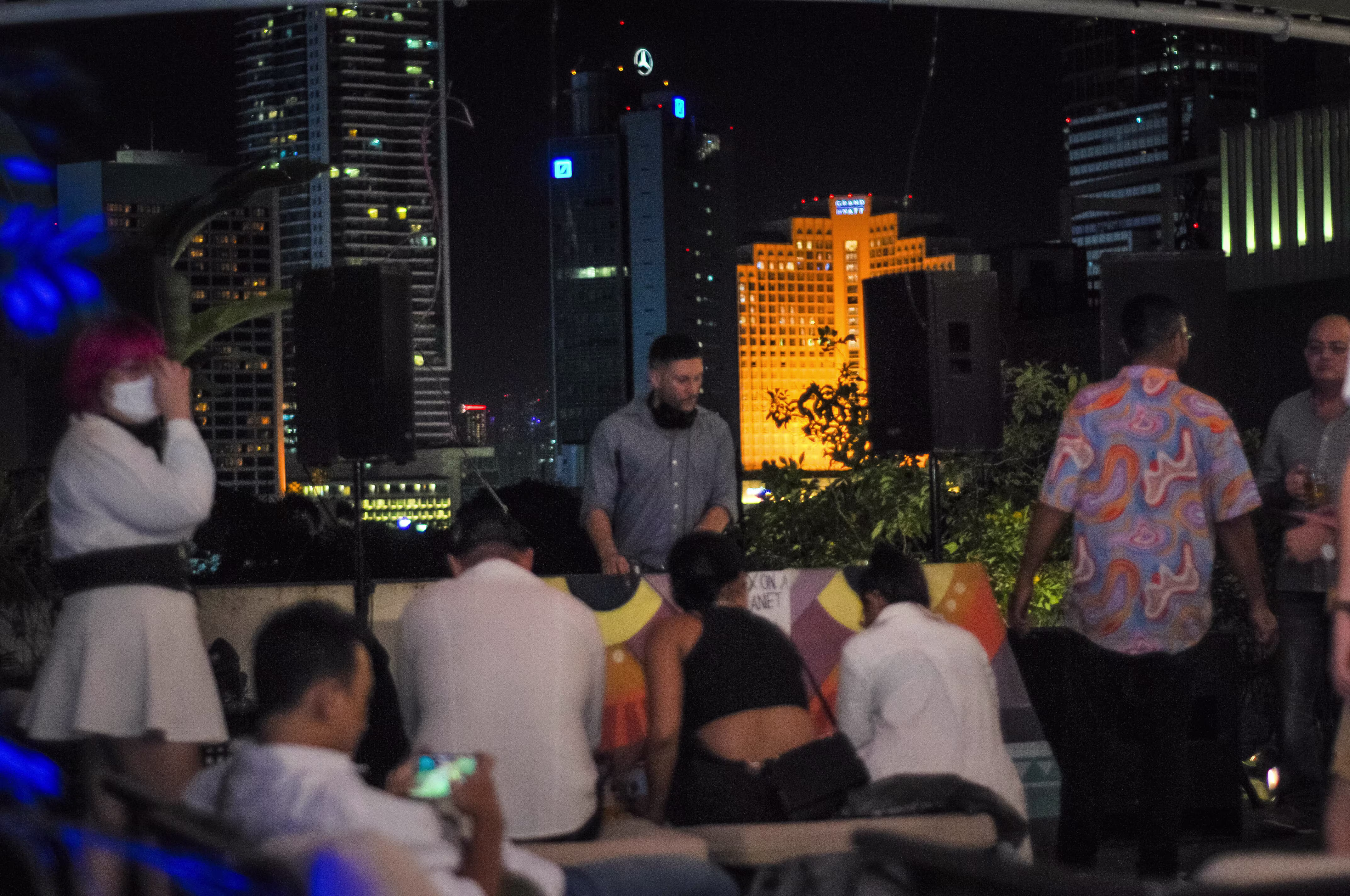 A male DJ spinning tracks live on stage during the Laciasmara 7th anniversary party at the ¡Porqué No! rooftop venue