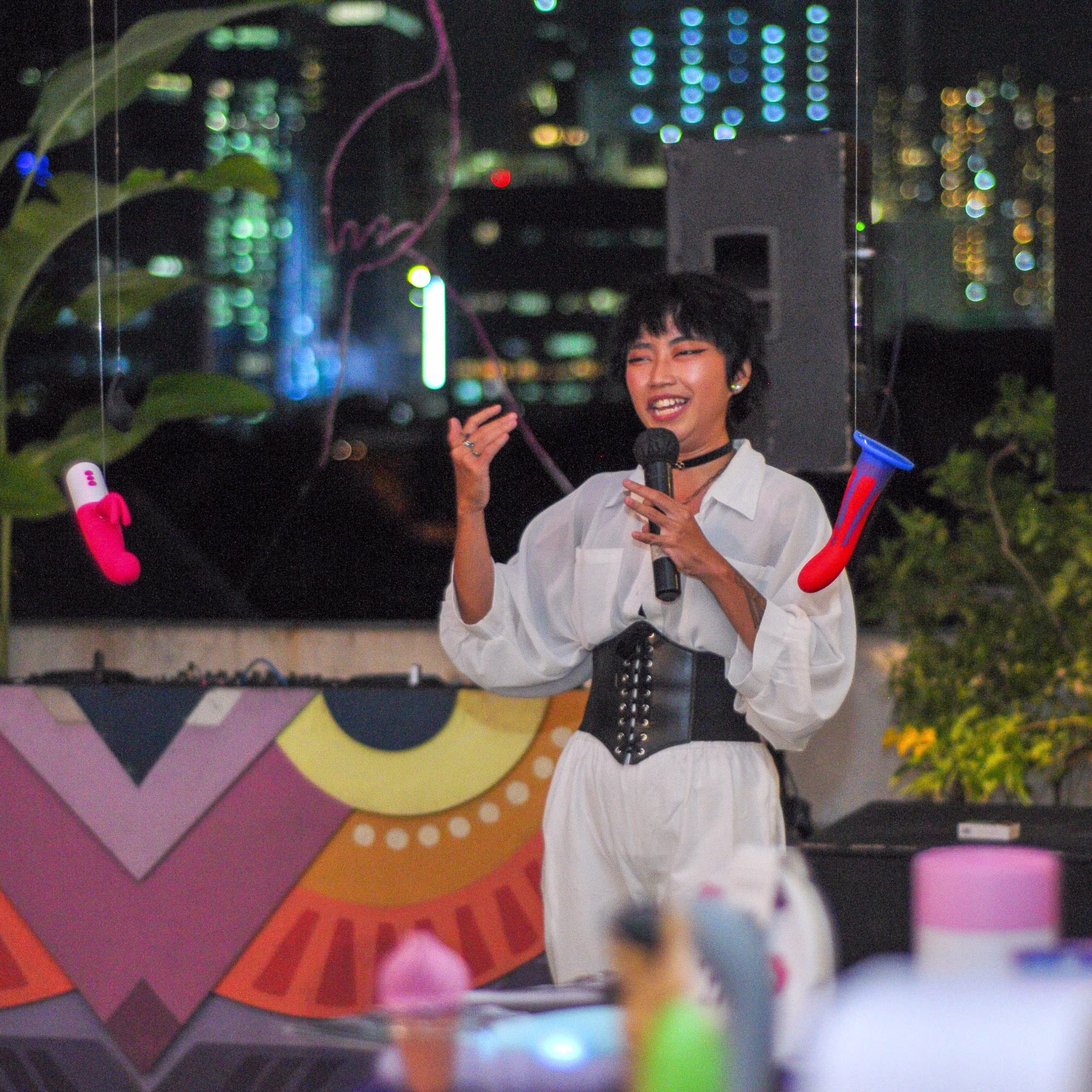 Comedian Annie Yang performing live on stage with a microphone during the Teman Asmara Bersua anniversary show