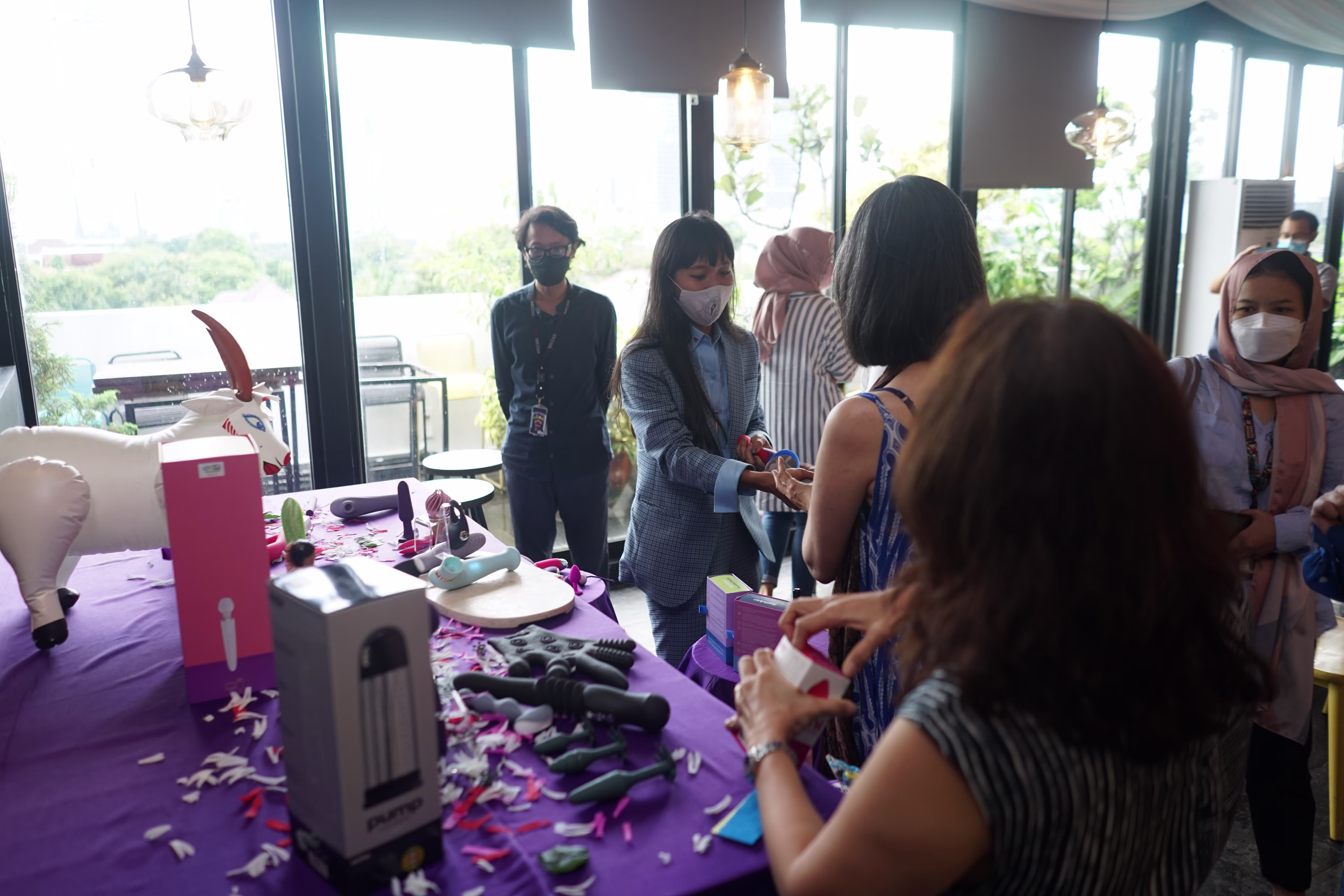 Attendees gathering around the exhibition table, showing curiosity and interest in the sexual health and intimacy products