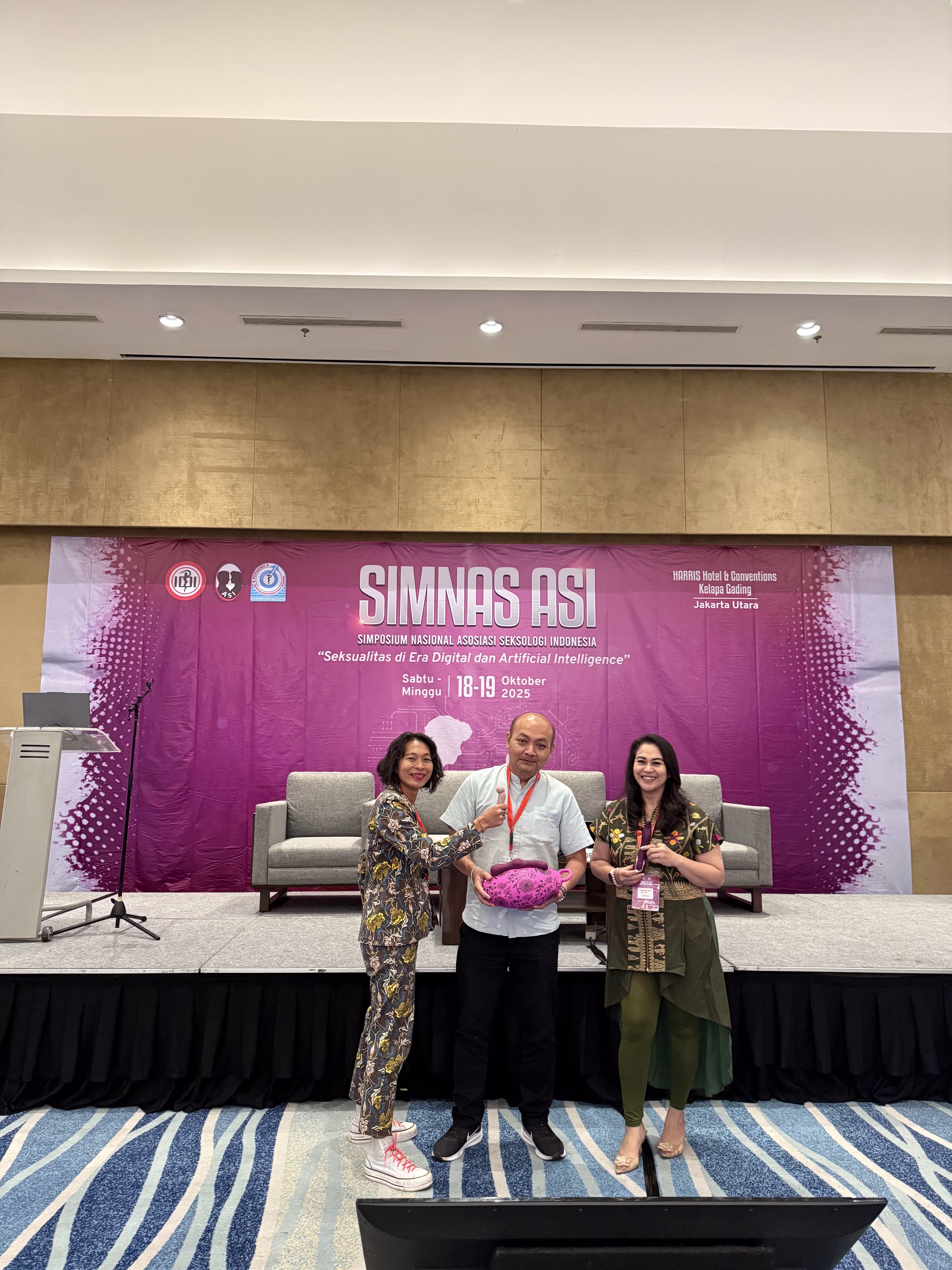 Rendra Susanti, dr. I Made Oka Negara, S.Ked., FIAS, M.Biomed and Zoya Amirin in the SIMNAS ASI 2025 stage holding sex instruments